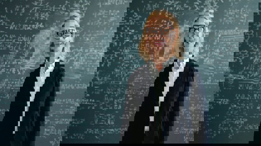 Foto: Unsplash. Kvinna framför griffeltavla.