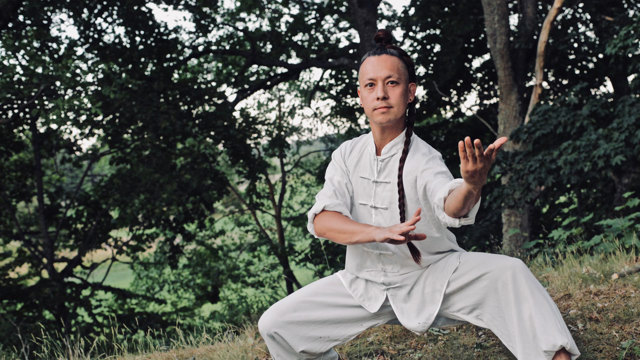 Portättbild Jens Choong, man i vita kläder i naturen.